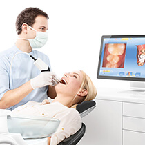 Dentist looking at digital impression of patient’s teeth