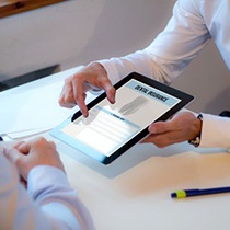 Team member reviewing a patient’s dental insurance policy on a tablet